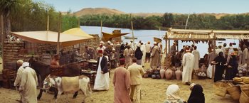 Movie still from “Death on the Nile” (2022), directed by Kenneth Branagh – A group of people standing next to each other on a dirt field; Extreme Wide shot, High angle