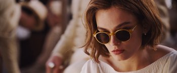 Movie still from “Death on the Nile” (2022), directed by Kenneth Branagh – A person wearing a pair of sunglasses; Close Up shot, Over the shoulder angle