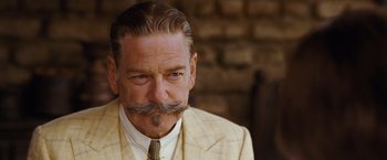Movie still from “Death on the Nile” (2022), directed by Kenneth Branagh – An older man with a mustache wearing a suit and tie; Close Up shot, Low angle
