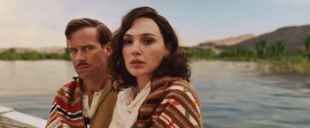 Movie still from “Death on the Nile” (2022), directed by Kenneth Branagh – A man and a woman standing next to a body of water; Close Up shot, Over the shoulder angle