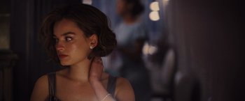 Movie still from “Death on the Nile” (2022), directed by Kenneth Branagh – A woman with her hands on her neck; Close Up shot, Over the shoulder angle