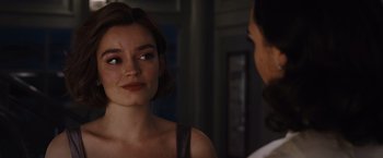 Movie still from “Death on the Nile” (2022), directed by Kenneth Branagh – A woman looking at another woman in front of a building; Close Up shot, Over the shoulder angle