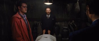 Movie still from “Death on the Nile” (2022), directed by Kenneth Branagh – A man standing next to a person in a room; Medium shot, High angle