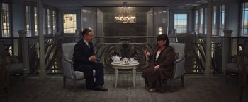 Movie still from “Death on the Nile” (2022), directed by Kenneth Branagh – A man and a woman sitting in front of a table; Wide shot, High angle