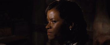 Movie still from “Death on the Nile” (2022), directed by Kenneth Branagh – A black woman looking to her left in the dark; Close Up shot, Over the shoulder angle