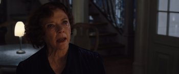 Movie still from “Death on the Nile” (2022), directed by Kenneth Branagh – An older woman sitting in front of a stair case; Close Up shot, Over the shoulder angle