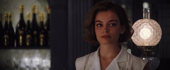 Movie still from “Death on the Nile” (2022), directed by Kenneth Branagh – A woman in a white shirt is looking at the camera; Close Up shot, Over the shoulder angle