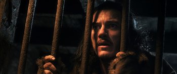 Movie still from “The Hobbit: The Battle of the Five Armies” (2014), directed by Peter Jackson – A person behind a fence; Close Up shot, Low angle