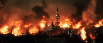 Movie still from “The Hobbit: The Battle of the Five Armies” (2014), directed by Peter Jackson – A large fire burning in the background of a building; Extreme Wide shot, High angle