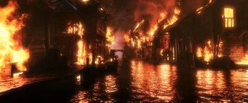 Movie still from “The Hobbit: The Battle of the Five Armies” (2014), directed by Peter Jackson – A boat traveling down a river next to burning buildings; Extreme Wide shot, High angle