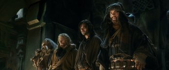 Movie still from “The Hobbit: The Battle of the Five Armies” (2014), directed by Peter Jackson – A group of men standing next to each other; Wide shot, Low angle