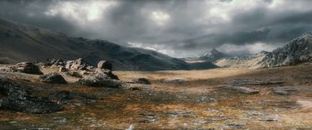 Movie still from “The Hobbit: The Battle of the Five Armies” (2014), directed by Peter Jackson – A large rock in the middle of a grassy field; Extreme Wide shot, High angle