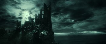 Movie still from “The Hobbit: The Battle of the Five Armies” (2014), directed by Peter Jackson – A dark picture of an old ruined castle; Extreme Wide shot, High angle