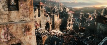 Movie still from “The Hobbit: The Battle of the Five Armies” (2014), directed by Peter Jackson – An aerial view of an old castle with a bunch of people walking around it; Extreme Wide shot, High angle