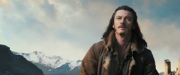 Movie still from “The Hobbit: The Battle of the Five Armies” (2014), directed by Peter Jackson – A person with long hair wearing a coat; Close Up shot, Low angle
