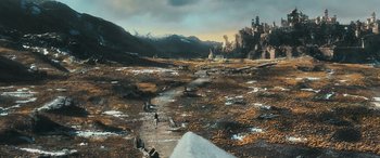 Movie still from “The Hobbit: The Battle of the Five Armies” (2014), directed by Peter Jackson – People are walking on a path in the middle of a field; Extreme Wide shot, High angle