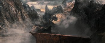 Movie still from “The Hobbit: The Battle of the Five Armies” (2014), directed by Peter Jackson – A mountain range with a cliff in the middle of it; Extreme Wide shot, High angle
