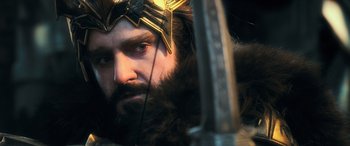 Movie still from “The Hobbit: The Battle of the Five Armies” (2014), directed by Peter Jackson – A person with a beard wearing a helmet; Close Up shot, Over the shoulder angle