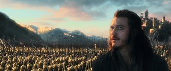 Movie still from “The Hobbit: The Battle of the Five Armies” (2014), directed by Peter Jackson – A man standing in front of a large group of soldiers; Medium shot, High angle