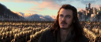 Movie still from “The Hobbit: The Battle of the Five Armies” (2014), directed by Peter Jackson – A man with long brown hair standing in front of a crowd of people; Close Up shot, Low angle