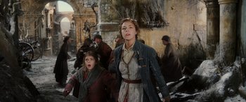 Movie still from “The Hobbit: The Battle of the Five Armies” (2014), directed by Peter Jackson – Two young women are walking through the ruins of an old city; Medium shot, Low angle