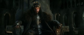 Movie still from “The Hobbit: The Battle of the Five Armies” (2014), directed by Peter Jackson – A man in a costume sitting on a chair; Medium shot, High angle