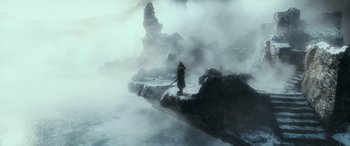 Movie still from “The Hobbit: The Battle of the Five Armies” (2014), directed by Peter Jackson – A person standing on a bridge in the middle of the fog; Extreme Wide shot, High angle