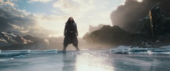 Movie still from “The Hobbit: The Battle of the Five Armies” (2014), directed by Peter Jackson – A man standing in the middle of a body of water; Wide shot, Low angle
