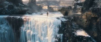 Movie still from “The Hobbit: The Battle of the Five Armies” (2014), directed by Peter Jackson – A man standing on top of an icy waterfall; Extreme Wide shot, High angle
