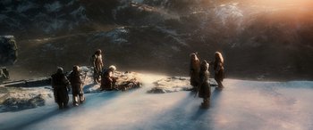 Movie still from “The Hobbit: The Battle of the Five Armies” (2014), directed by Peter Jackson – A group of people standing on top of a snow covered slope; Wide shot, High angle