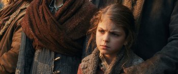Movie still from “The Hobbit: The Battle of the Five Armies” (2014), directed by Peter Jackson – A young girl wearing a brown jacket and a brown scarf; Close Up shot, Over the shoulder angle