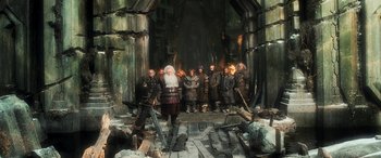 Movie still from “The Hobbit: The Battle of the Five Armies” (2014), directed by Peter Jackson – A group of men standing in front of an old man; Wide shot, Low angle
