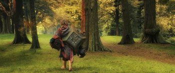 Movie still from “The Hobbit: The Battle of the Five Armies” (2014), directed by Peter Jackson – A man in a costume walking in the woods; Wide shot, Low angle