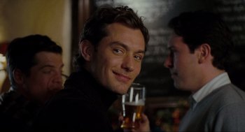 Movie still from “The Holiday” (2006), directed by Nancy Meyers – A man holding a glass of beer in his right hand; Close Up shot, Over the shoulder angle