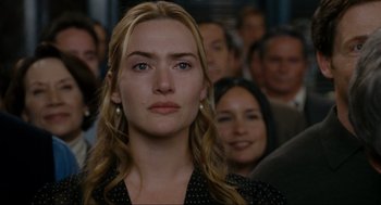 Movie still from “The Holiday” (2006), directed by Nancy Meyers – A person with a crowd of people in the background; Close Up shot, Over the shoulder angle