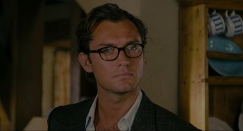 Movie still from “The Holiday” (2006), directed by Nancy Meyers – A person wearing glasses and a suit; Close Up shot, Over the shoulder angle