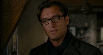 Movie still from “The Holiday” (2006), directed by Nancy Meyers – A person wearing glasses and a suit; Close Up shot, Over the shoulder angle