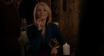 Movie still from “The Holiday” (2006), directed by Nancy Meyers – A woman sitting at a table with a glass of wine; Medium shot, Over the shoulder angle