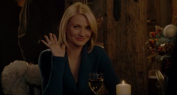 Movie still from “The Holiday” (2006), directed by Nancy Meyers – A woman sitting in front of a wine glass and a candle; Medium shot, Over the shoulder angle