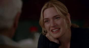 Movie still from “The Holiday” (2006), directed by Nancy Meyers – A person smiling with her hand on her chin; Close Up shot, Over the shoulder angle