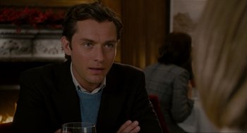 Movie still from “The Holiday” (2006), directed by Nancy Meyers – A person sitting at a table with a glass of wine; Close Up shot, Over the shoulder angle