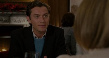 Movie still from “The Holiday” (2006), directed by Nancy Meyers – A man sitting at a table with a glass of wine; Close Up shot, Over the shoulder angle