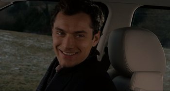 Movie still from “The Holiday” (2006), directed by Nancy Meyers – A man sitting in the back seat of a car; Close Up shot, Over the shoulder angle