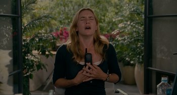 Movie still from “The Holiday” (2006), directed by Nancy Meyers – A woman holding a cell phone up to her face; Medium shot, Low angle