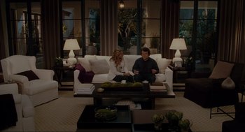 Movie still from “The Holiday” (2006), directed by Nancy Meyers – A man and a woman sitting on a couch in a living room; Wide shot, High angle