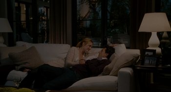 Movie still from “The Holiday” (2006), directed by Nancy Meyers – A woman and a man are laying on a white couch; Wide shot, High angle