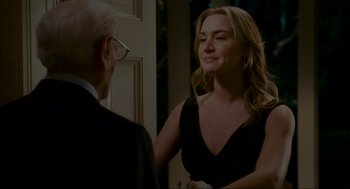 Movie still from “The Holiday” (2006), directed by Nancy Meyers – A woman in a black dress talking to an older man; Medium shot, Over the shoulder angle