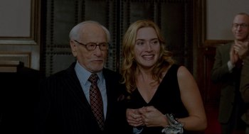 Movie still from “The Holiday” (2006), directed by Nancy Meyers – An older man and a younger woman posing for a picture; Medium shot, Over the shoulder angle