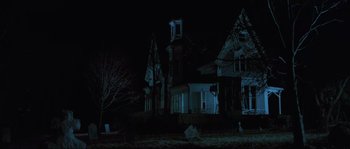 Movie still from “The House by the Cemetery” (1981), directed by Lucio Fulci – A house that is lit up at night time; Extreme Wide shot, Low angle