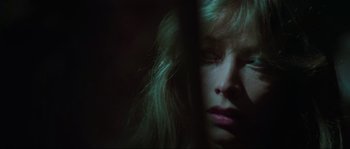 Movie still from “The House by the Cemetery” (1981), directed by Lucio Fulci – A woman with long blonde hair looking out of a window; Extreme Close Up shot, Low angle